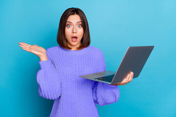 Portrait of attractive amazed clueless girl using laptop new web offer isolated over bright blue color background