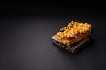 Sandwich with brioche, meat, melted cheese, corn, salt, spices and herbs