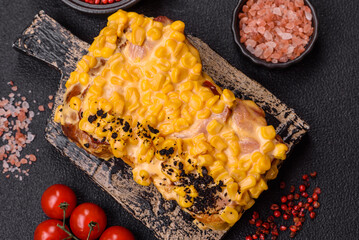 Sandwich with brioche, meat, melted cheese, corn, salt, spices and herbs