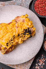 Sandwich with brioche, meat, melted cheese, corn, salt, spices and herbs