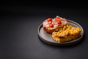 Sandwich with brioche, meat, melted cheese, ham, tomatoes, salt, spices and herbs