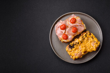 Sandwich with brioche, meat, melted cheese, ham, tomatoes, salt, spices and herbs