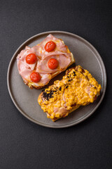 Sandwich with brioche, meat, melted cheese, ham, tomatoes, salt, spices and herbs