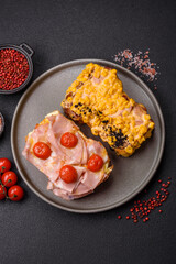 Sandwich with brioche, meat, melted cheese, ham, tomatoes, salt, spices and herbs