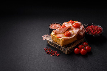 Sandwich with brioche, meat, melted cheese, ham, tomatoes, salt, spices and herbs