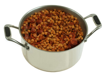 Faitout de pois chiches et rondelles de chorizo en gros plan sur fond blanc.