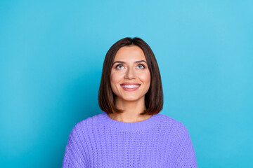 Fototapeta premium Portrait of attractive curious cheerful brown-haired girl looking up copy empty space clue isolated over bright blue color background