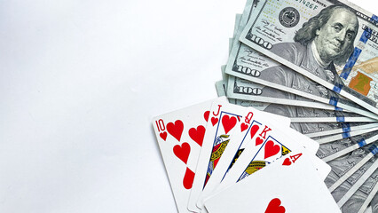 A royal flush in hearts displayed with a fan of hundred dollar bills on a white background. This image symbolizes gambling, luxury, and success, perfect for casino promotions, poker tournaments