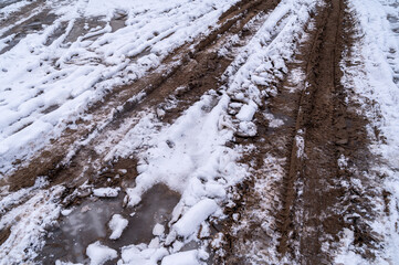 Tire tracks in the ice mud of winter in rural with snow. Off-road in frozen land. Landscape nature background.