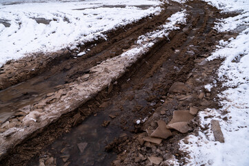 Tire tracks in the ice mud of winter in rural with snow. Off-road in frozen land. Landscape nature background.