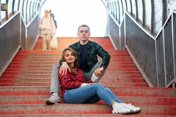 Romantic Couple Sitting on Stairs in Urban Setting with Red Tones