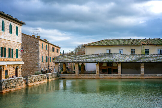 Bagno Vignoni hot springs pool with traditional Tuscan buildings, Tuscany, Italy
