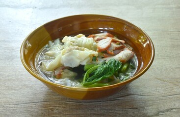 Chinese dumpling topping slice red barbecue pork with clear soup on bowl