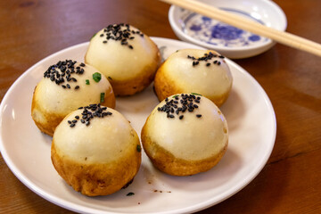 Pan-Fried Pork Buns, or shengjian bao with sesame on top.