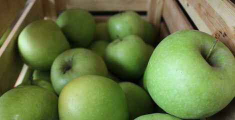 Fresh green apple in wooden basket. Image