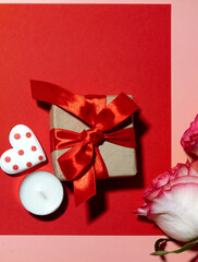 Vertical Valentines Day background with blank paper card mockup, gifts, red hearts, confetti on pink.