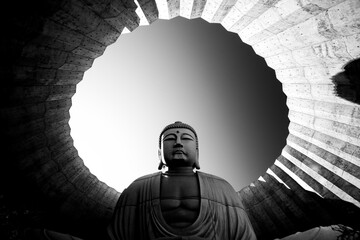 Black and white image of a Buddha statue framed in circular architecture, Hill of the Buddha, Sapporo, Hokkaido, Japan