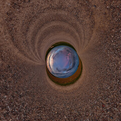 blue hole sphere or globe little planet inside green dry grass or stone with sand frame background