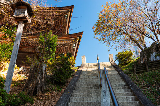 Stairs by a lantern leading up to a temple roof in autumn, Yoshino Yama, Honshu, Japan