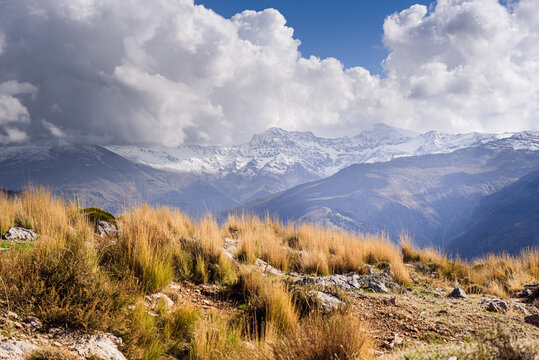 Dreamy mountain landscapes of Sierra Nevada Mulhacen, Alcazaba, Pico del Veleta wth snowy peaks, and golden dry alpine grassland, Granada, Andalusia, Spain