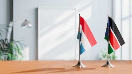 FLAGS OF LUXEMBOURG AND SOUTH SUDAN ON TABLE