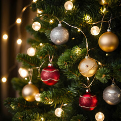 Beautiful baubles and string lights hanging on a Christmas tree