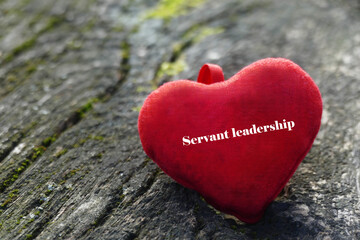 Fototapeta premium Servant leadership - red heart on wooden background