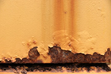 The steel wall is very old, rusted, peeled, cracked and dirty.