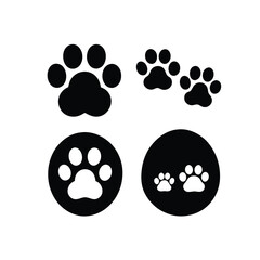 Fototapeta premium Four black paw prints are shown on a white background. The paw prints are all different sizes and shapes