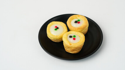 Mini cream puffs with glossy icing and colorful jelly sprinkles