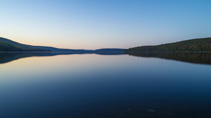 Serene Lakeside Twilight: Tranquil Waters Reflect Mountain Silhouettes at Dusk