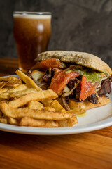 Smoked meat sandwich with chips and beer