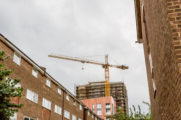 Urban construction crane against cloudy sky