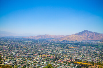 A stunning aerial panoramic view of Santiago, Chile, showcasing the city's vibrant urban landscape surrounded by majestic hills in the background. A blend of modern architecture and natural beauty