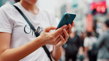 Hands, phone and woman online in city to check text, social media or blog post on account in Japan. Closeup, mobile and person outdoor for communication, notification or download chat app on internet