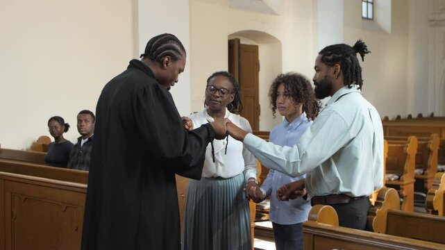 Priest giving communion to family in church slow motion