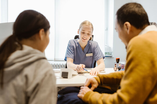 Female pediatrician prescribing medicines to patient in clinic at hospital