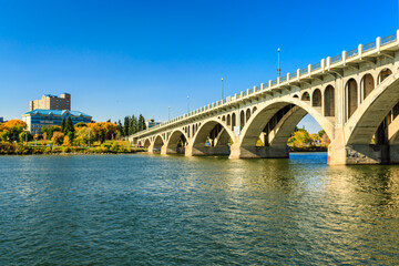 A bridge spans a river with a city in the background