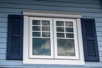 Window that reflects clouds and a clear sky