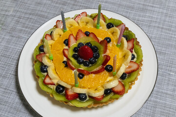 ろうそくを6本立てたフルーツタルトのお誕生日ケーキ