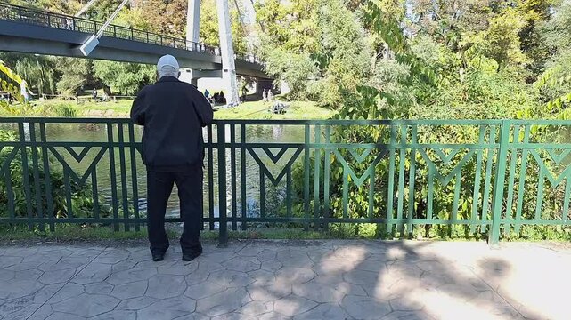 A person looking at the bridge and river in front of them on an autumn day in Oradea.