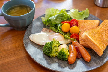 パンと卵とスープとフルーツのある朝食