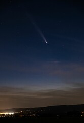 Comet over a starry night cityscape