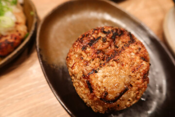 close up of grilled roasted rice ball or can be called onigiri on a black plate with copy space