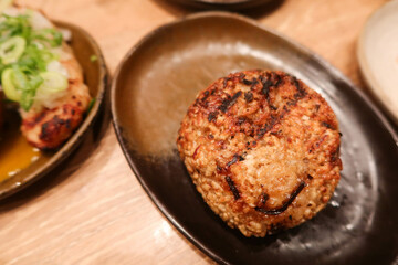 close up of grilled roasted rice ball or can be called onigiri on a black plate with copy space