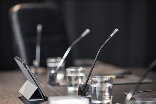 Side view of microphone and tablet computer placed on meeting table in conference room of local administration, copy space