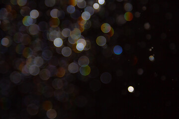 Abstract bokeh lights with colorful circles on dark background, creating a dreamy and festive atmosphere