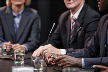 Cropped shot of African American politician at meeting table with microphones giving speech during press conference, copy space