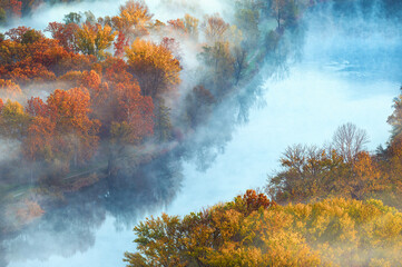 autumnal foggy morning sunrises over the Adda river, Lecco, Italy	
