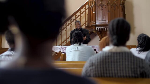 Congregation listening to priest giving sermon in church slow motion